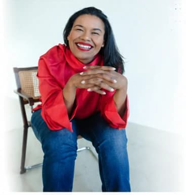 Deborah, Sounds Natural's founder and accent coach, smiling while seated